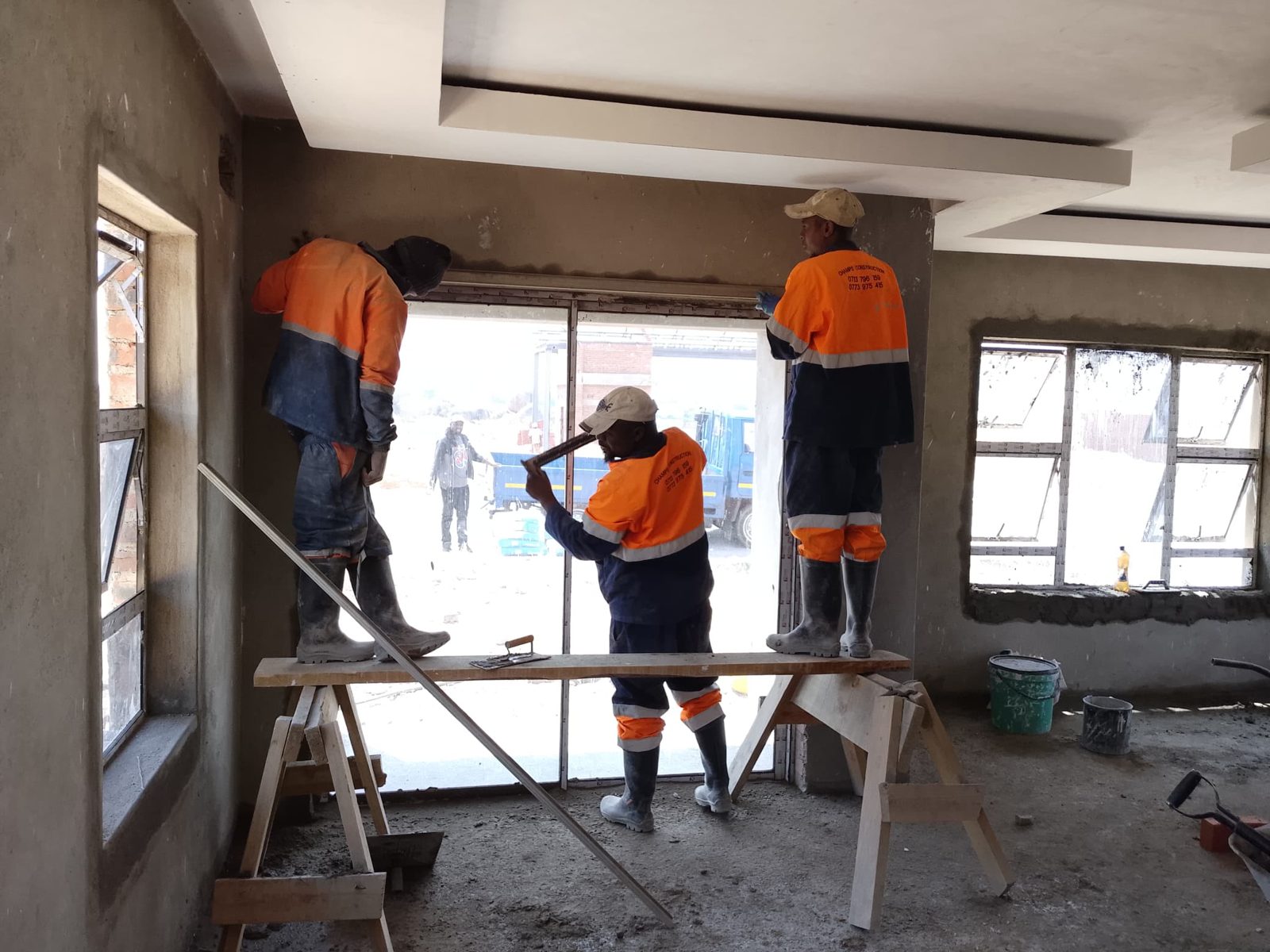 The Champs crew fitting a ceiling inside a house under construction