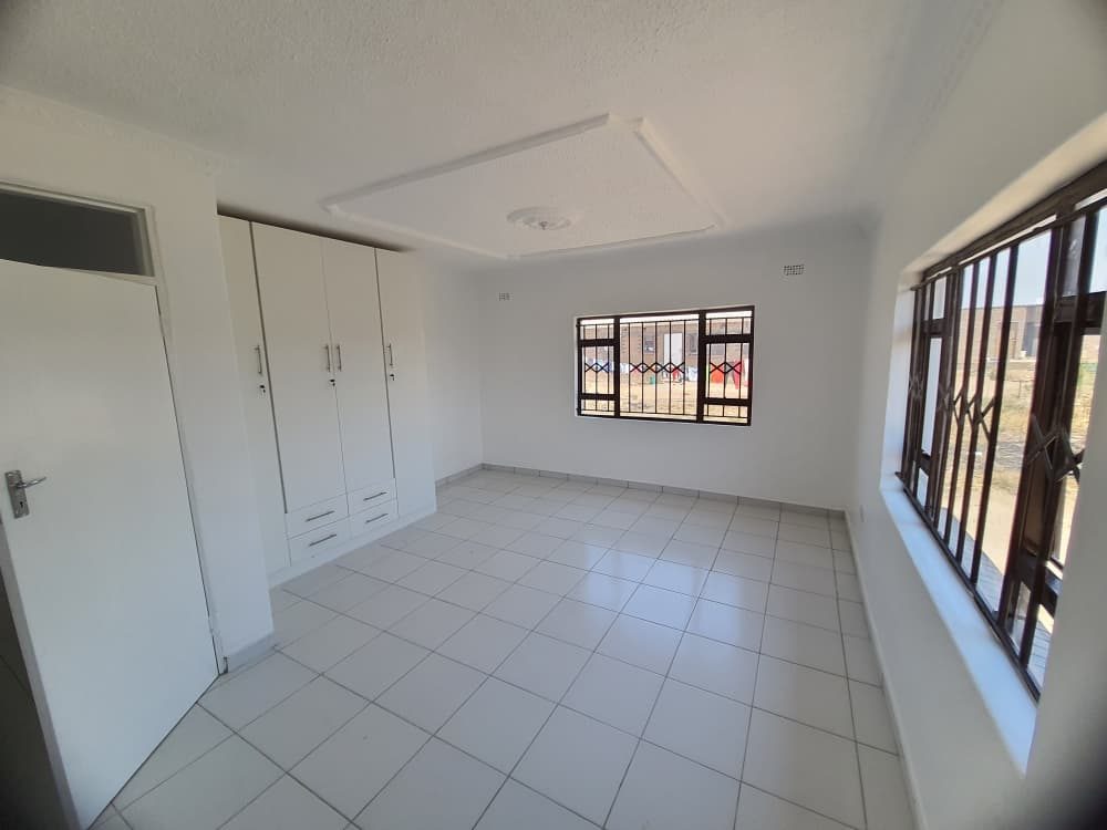 A bedroom with built-in wardrobes and tiled floor