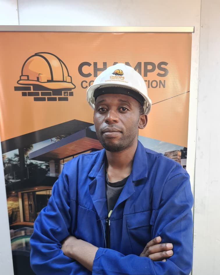 Mr M. Marume in a Champs hard hat and overalls